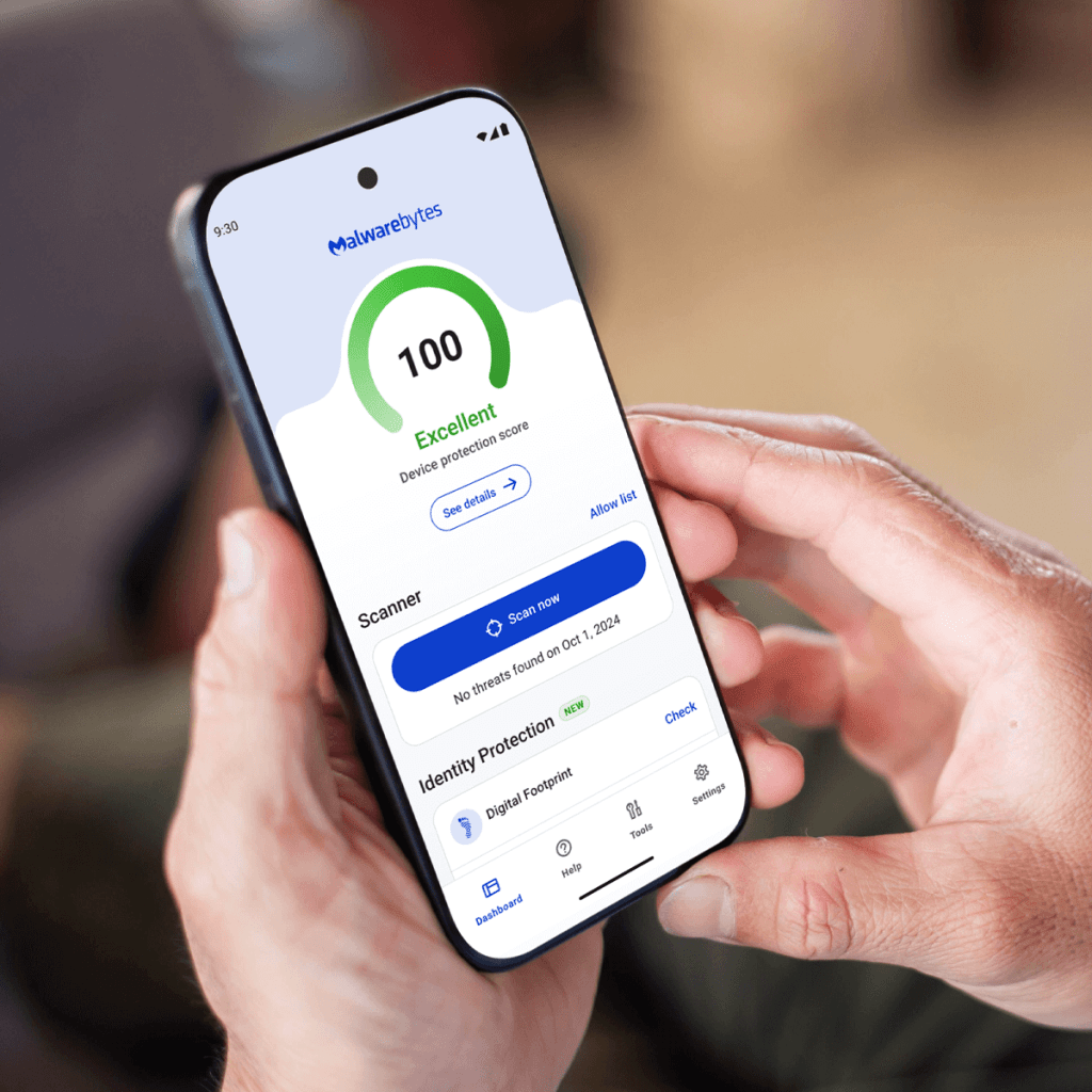Photo of hands holding a mobile phone with the Malwarebytes for Android dashboard on the screen